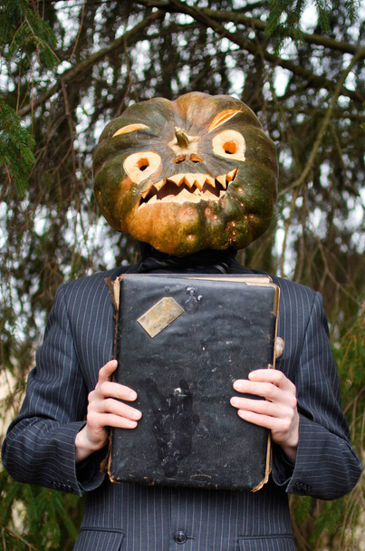 Halloween-Vogelscheuche im Business-Anzug mit einem alten Buch in der Hand - Foto, Bild