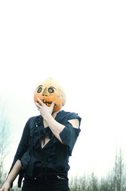 Halloween Strach na wróble z dynią na głowie w czarnych szmatach z niezadowoloną twarzą - Zdjęcie, obraz