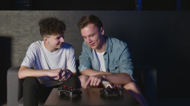 Jonge mannelijke vrienden bespreken strategie plan naar volgende game sessie - Video