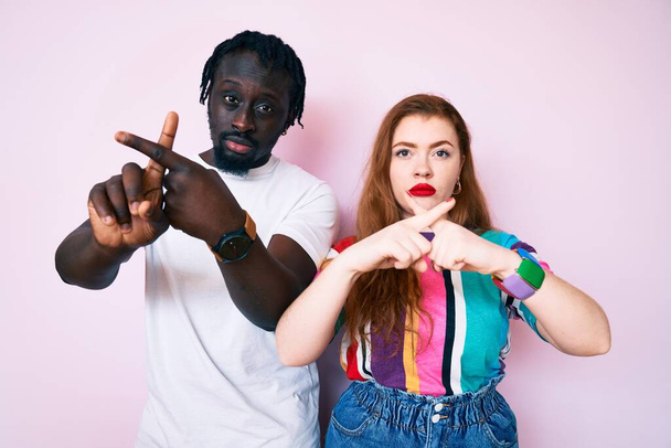 Interracial couple wearing casual clothes rejection expression crossing fingers doing negative sign  - Φωτογραφία, εικόνα