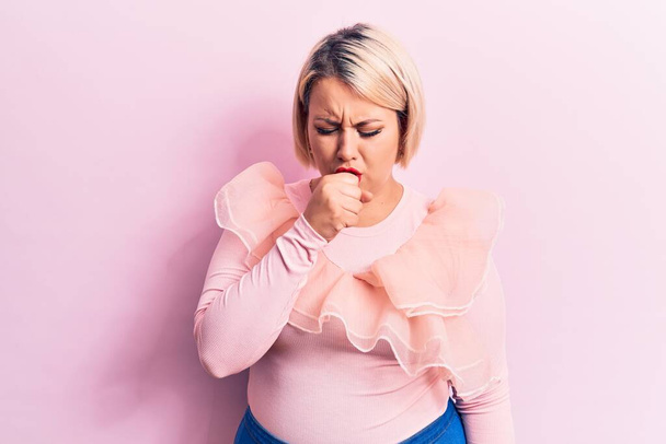 Молода красива блондинка плюс розмір жінка в повсякденному светрі над ізольованим рожевим тлом відчуває неприємність і кашель як симптом застуди або бронхіту. Концепція охорони здоров'я
. - Фото, зображення