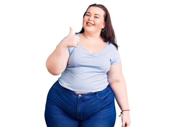 Young plus size woman wearing casual clothes doing happy thumbs up gesture with hand. approving expression looking at the camera showing success.  - Foto, Imagem