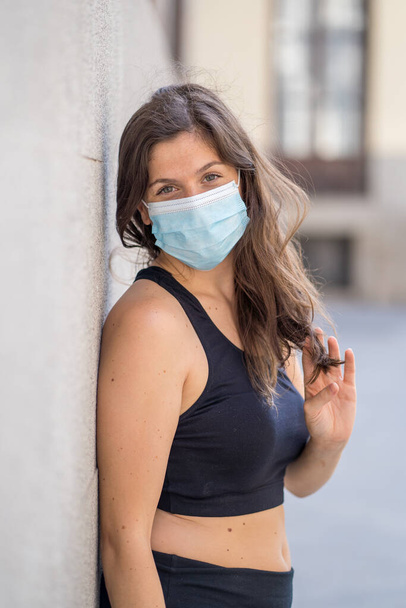 Young woman wearing surgical mask on face in public spaces. Coronavirus spreading protection mask protective against influenza viruses and diseases. Positive image of New Normal life after COVID-19 - Foto, imagen