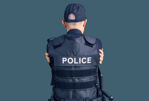Jovem bonitão vestindo uniforme policial abraçando-se feliz e positivo de trás para a frente. auto-amor e auto-cuidado  - Foto, Imagem
