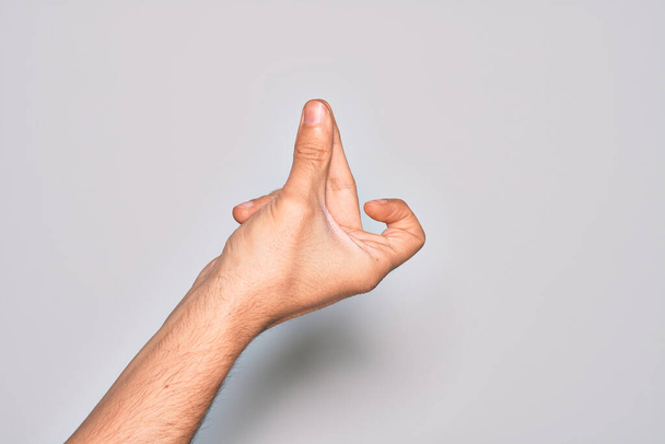 Hand eines kaukasischen jungen Mannes, der Finger über isoliertem weißem Hintergrund zeigt, Finger für den Erfolg schnippend, einfache und klicksymbolische Geste mit der Hand - Foto, Bild