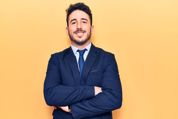 Young hispanic man wearing suit happy face smiling with crossed arms looking at the camera. positive person.  - Foto, imagen