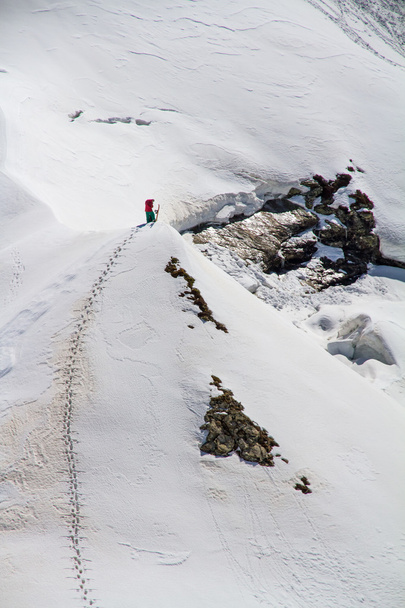 Skier climbing a snowy mountain - Фото, изображение