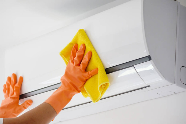Aziatische man schoonmaken airconditioner met microvezel doek - Foto, afbeelding