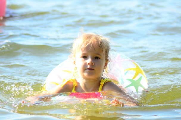 маленькая девочка плавает в озере - Фото, изображение