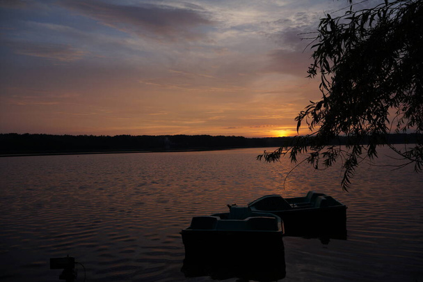 malerischer Blick auf den Sonnenuntergang, der sich auf der Spiegeloberfläche des Sees spiegelt  - Foto, Bild