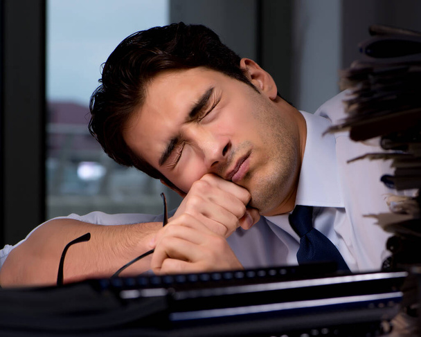 Joven hombre de negocios trabajando horas extras hasta tarde en el cargo - Foto, Imagen