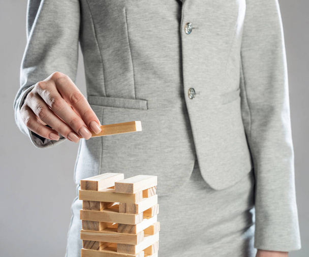 Business woman building tower from wooden blocks - Zdjęcie, obraz