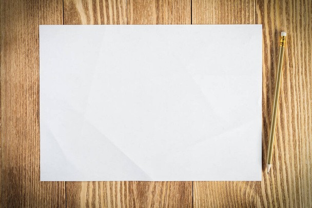 Sheet of paper lying on wooden table - Φωτογραφία, εικόνα