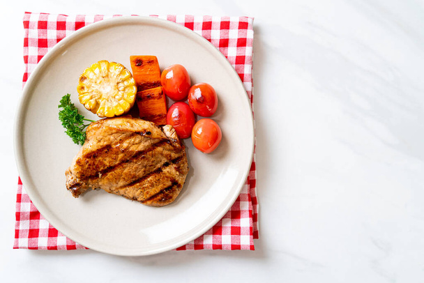 grilled and barbecue fillet pork steak with corn, carrot and tomatoes - Foto, afbeelding