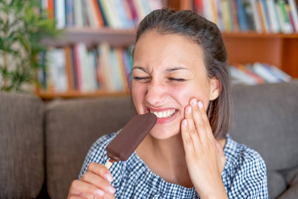 冷たい食べ物のために歯痛を患っている女性 - 写真・画像