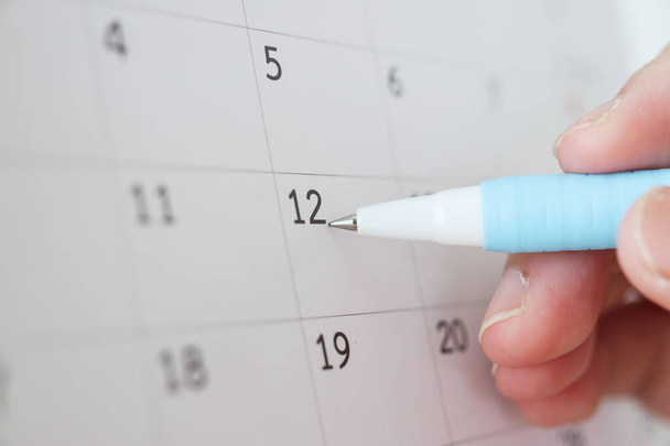 Рука с ручкой в календарную дату - Фото, изображение