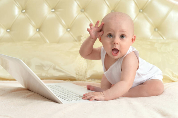 cute little baby girl with laptop on bed  - Photo, image