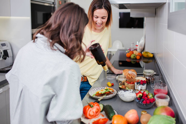 Einfaches gesundes Ernährungskonzept. Fröhliche Freunde kochen Gemüsesommersalat in der heimischen Küche - Foto, Bild