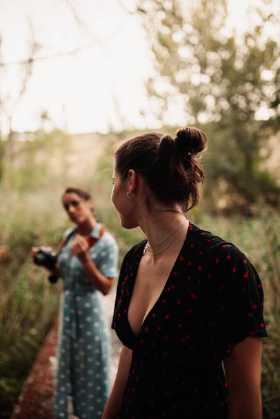 Két fiatal nő fotózza egymást az erdőben. - Fotó, kép