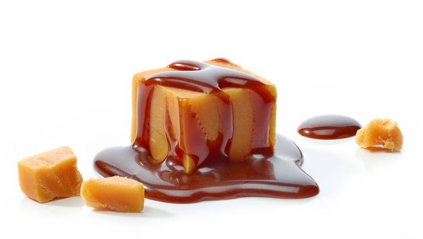 карамельные конфеты с шоколадным соусом на белом фоне - Фото, изображение