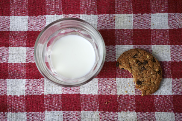 chocolate chip cookies with glass of milk on table red wagon - Photo, image