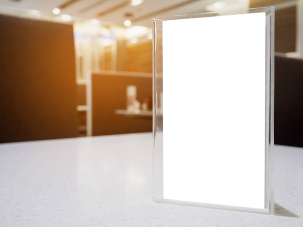 Moldura de menu Mock up na mesa no restaurante do café, suporte de acrílico com papel branco - Foto, Imagem