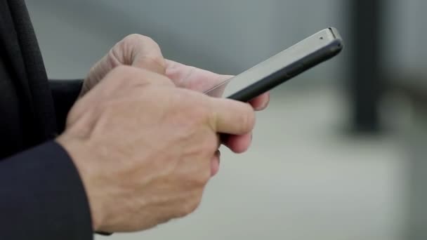 Kädet pitämällä älypuhelin ja kirjoittamalla kosketusnäytöllä - Materiaali, video