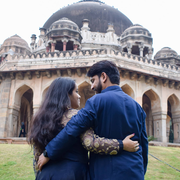 Νέο Δελχί Ινδία Νοέμβριος 25 2020 - Ένα ζευγάρι θέτουν για προ γάμου πυροβολούν μέσα Lodhi Garden Δελχί, ένα δημοφιλές τουριστικό ορόσημο στο Νέο Δελχί της Ινδίας, για την προ-γαμήλια φωτογράφιση τους, Προ-γαμήλια φωτογράφιση - Φωτογραφία, εικόνα