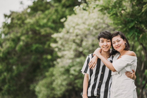 Birbirine aşık iki mutlu Asyalı lezbiyen çift parkta sarılıp kucaklaşıyorlar. Lgbt kavramı - Fotoğraf, Görsel