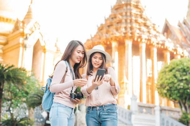 Turystki najlepszy przyjaciel cieszyć podróży w świątyni szmaragdowej budda, Wat Phra Kaew popularne miejsce turystyczne w Bangkoku, Tajlandia, sprawdzanie kierunku w smartphone mobile - Zdjęcie, obraz