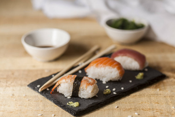 A closeup shot of salmon nigiri sushi on a wooden table - Photo, image