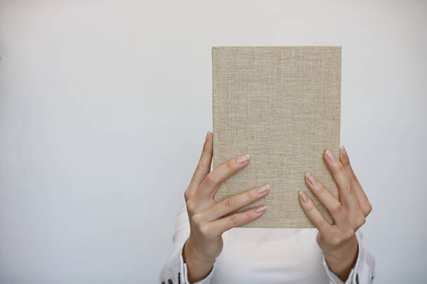 Una joven sostiene un libro en su mano - Foto, Imagen