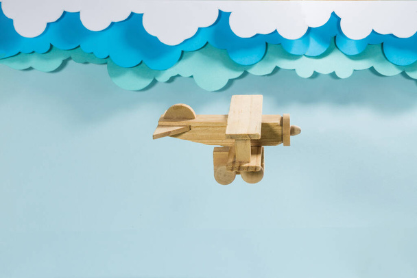 Paper figurines of clouds and a wooden plane - Photo, image