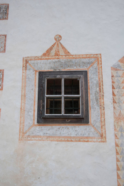 piccola finestra su un edificio bianco, decorazioni dipinte intorno alla finestra - Foto, immagini