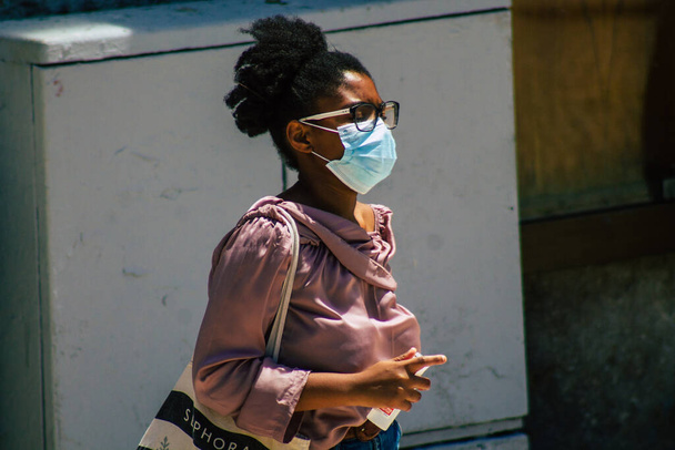 Lizbon 3 Ağustos 2020 'de Portekiz' in başkenti Lizbon 'un tarihi caddelerinde yürüyen koronavirüsten kendilerini korumak için maske takan kimliği belirsiz yayalara baktık. - Fotoğraf, Görsel