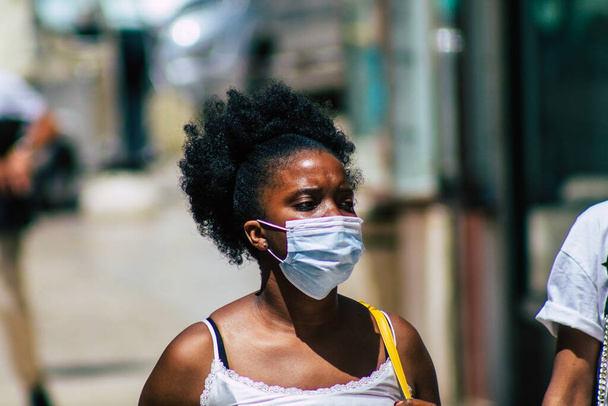 Lizbon 3 Ağustos 2020 'de Portekiz' in başkenti Lizbon 'un tarihi caddelerinde yürüyen koronavirüsten kendilerini korumak için maske takan kimliği belirsiz yayalara baktık. - Fotoğraf, Görsel