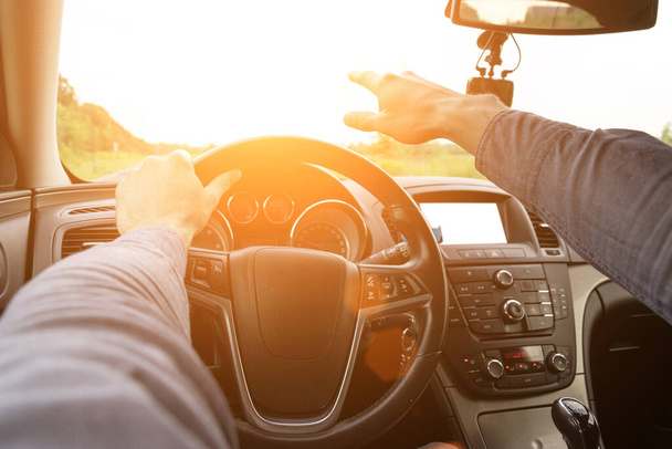Travel car trip on road at sunset. Happy young man have fun driving inside vehicle in summer sunny day. Driver ride vacation concept - Photo, Image
