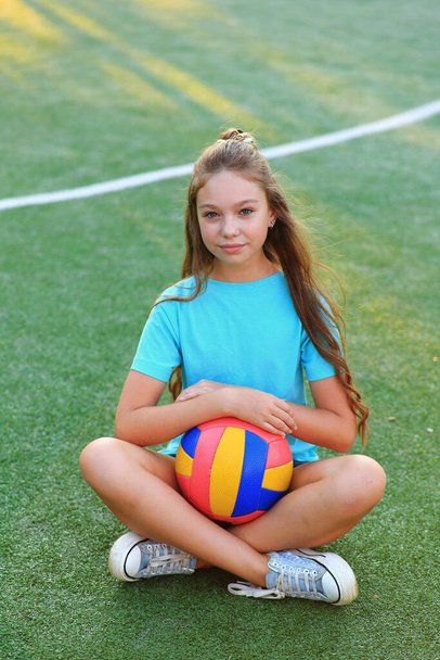 Girl with a ball in his hands on the football field. - Valokuva, kuva