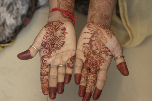 Mehndi ontwerp. rode kleur mehndi ontwerp met twee handen van meisje, holi mehndi ontwerp en patroon op vrouw handen - Foto, afbeelding