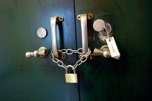 bóveda verde pesada del banco para guardar el dinero y los objetos de valor, asegurados con cadena y cerraduras - Foto, imagen