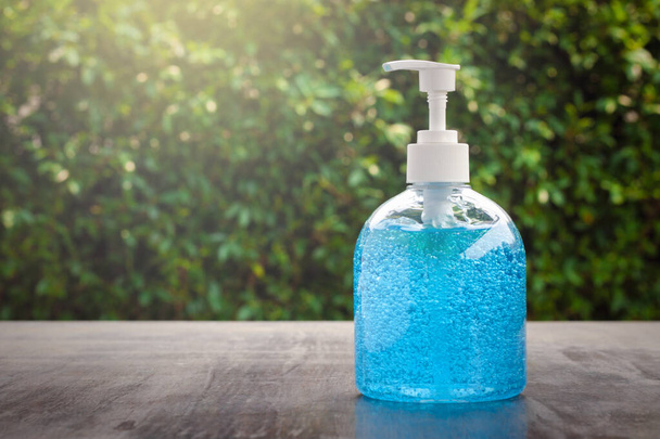 Αντλία μπουκαλιού με μπλε τζελ χειρός αλκοόλ. Gel καθαρισμού χεριών και αντιβακτηριδιακό οινόπνευμα τρίψιμο μπορεί να βοηθήσει επιδημία και την προστασία από coronavirus με bokeh φόντο. - Φωτογραφία, εικόνα
