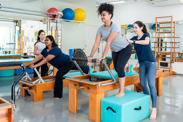 Pilates eğitmenleri anne ve kızına rehberlik ediyor.. - Fotoğraf, Görsel