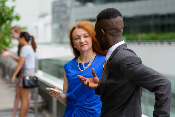 Portrait of young African businessman and young businesswoman with red hair together - Photo, Image