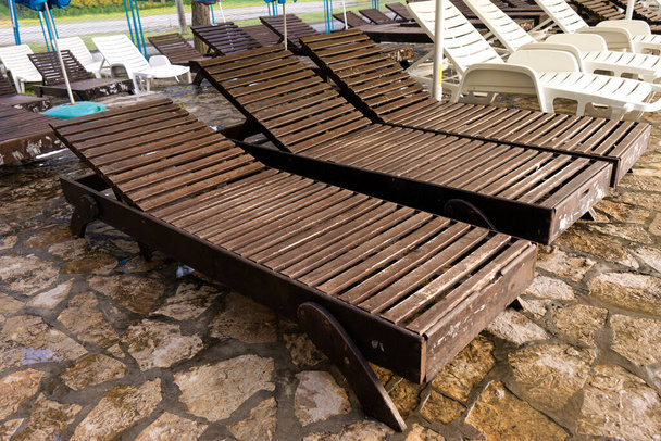 Порожні дерев'яні стільці біля басейну
 - Фото, зображення