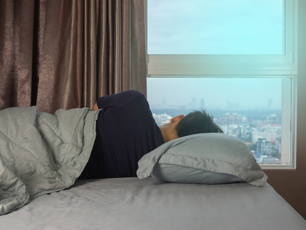Man sleeping on the bed with sun light - Valokuva, kuva