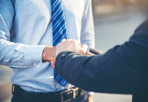 Team Business Partners shaking hands together to Greeting Start up new project. Corporate Teamwork Partnership outside office modern city as background. Businessman with Hands together. - Photo, Image