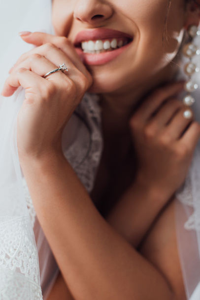Przycięty widok młodej panny młodej w biżuterii pierścień dotykając welon koronki  - Zdjęcie, obraz