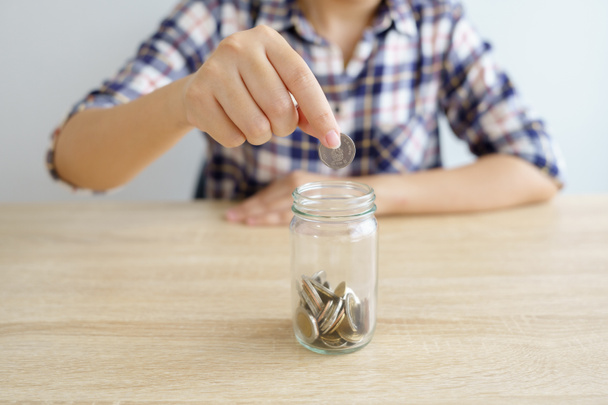 Businesswomen Put the coin in a glass jar To save money, save money on investments, spend money when needed And use in the future. Investment concept. Savings with copy spaces. - Photo, Image