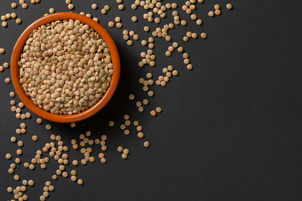 Top view of a bowl with lentils on a black background. - Photo, Image