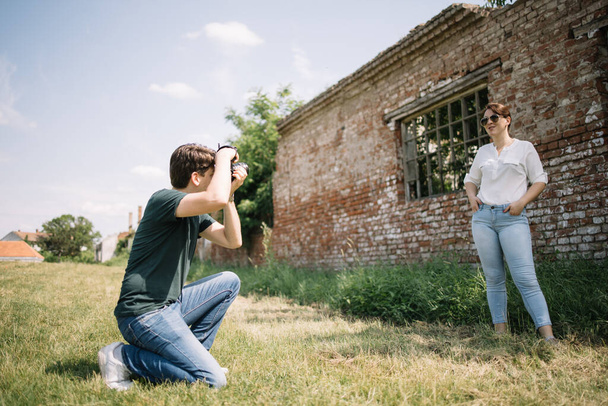 Side view of man taking photos of girl outdoor - Photo, image